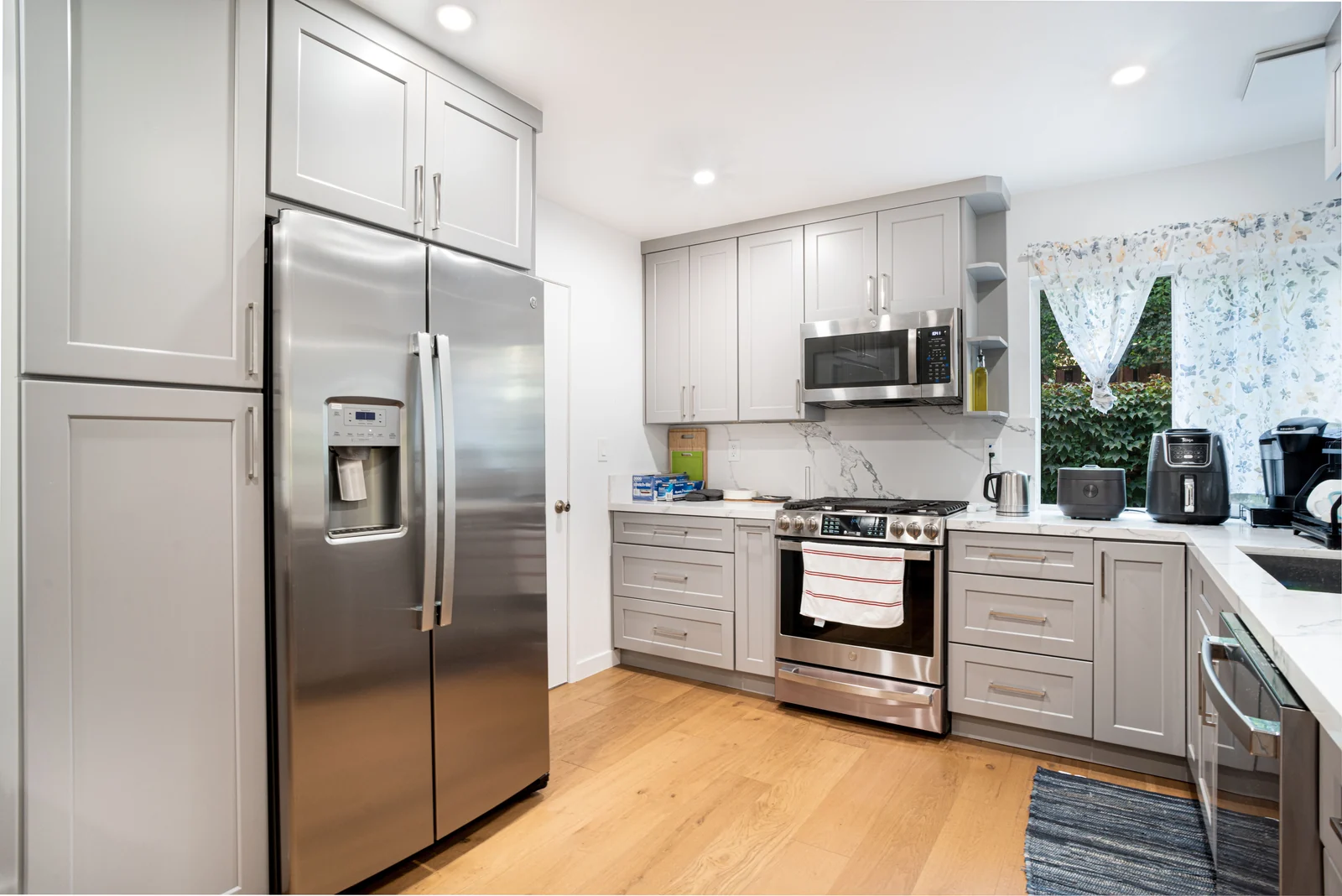 Light grey shaker cabinets with a marble-effect backsplash