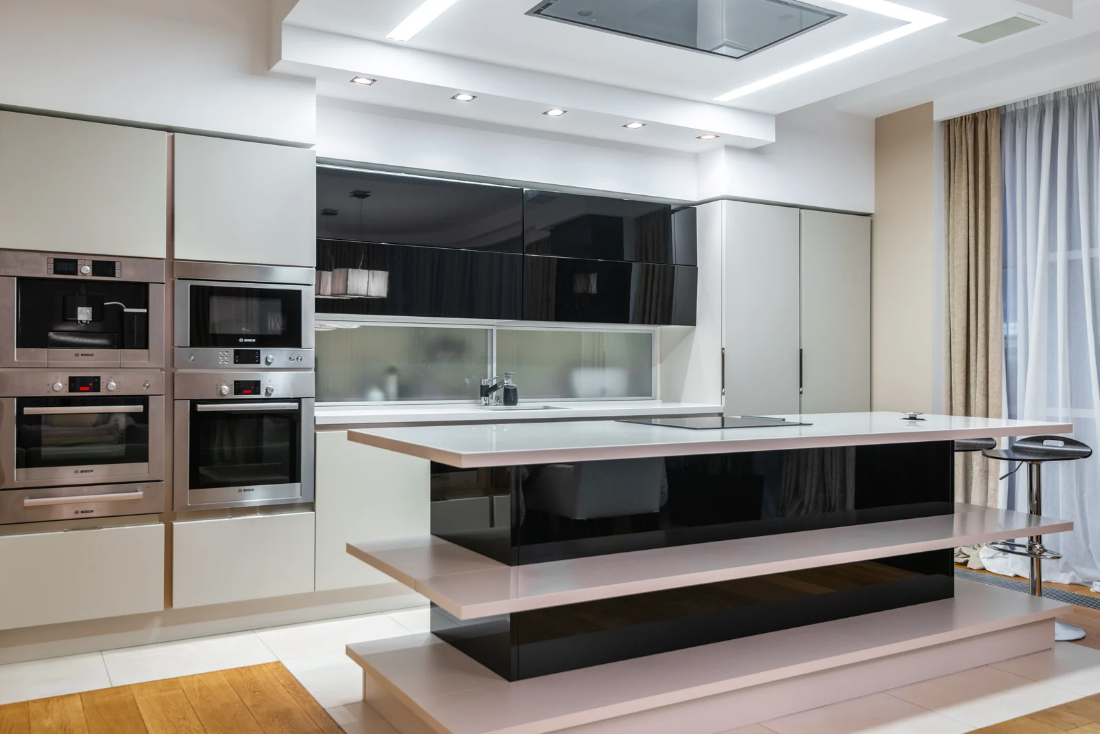 Handleless cream cabinetry with a black gloss island